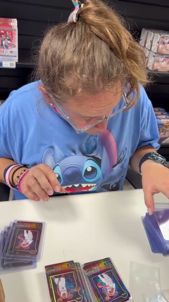 A person looking closely at trading cards at a table