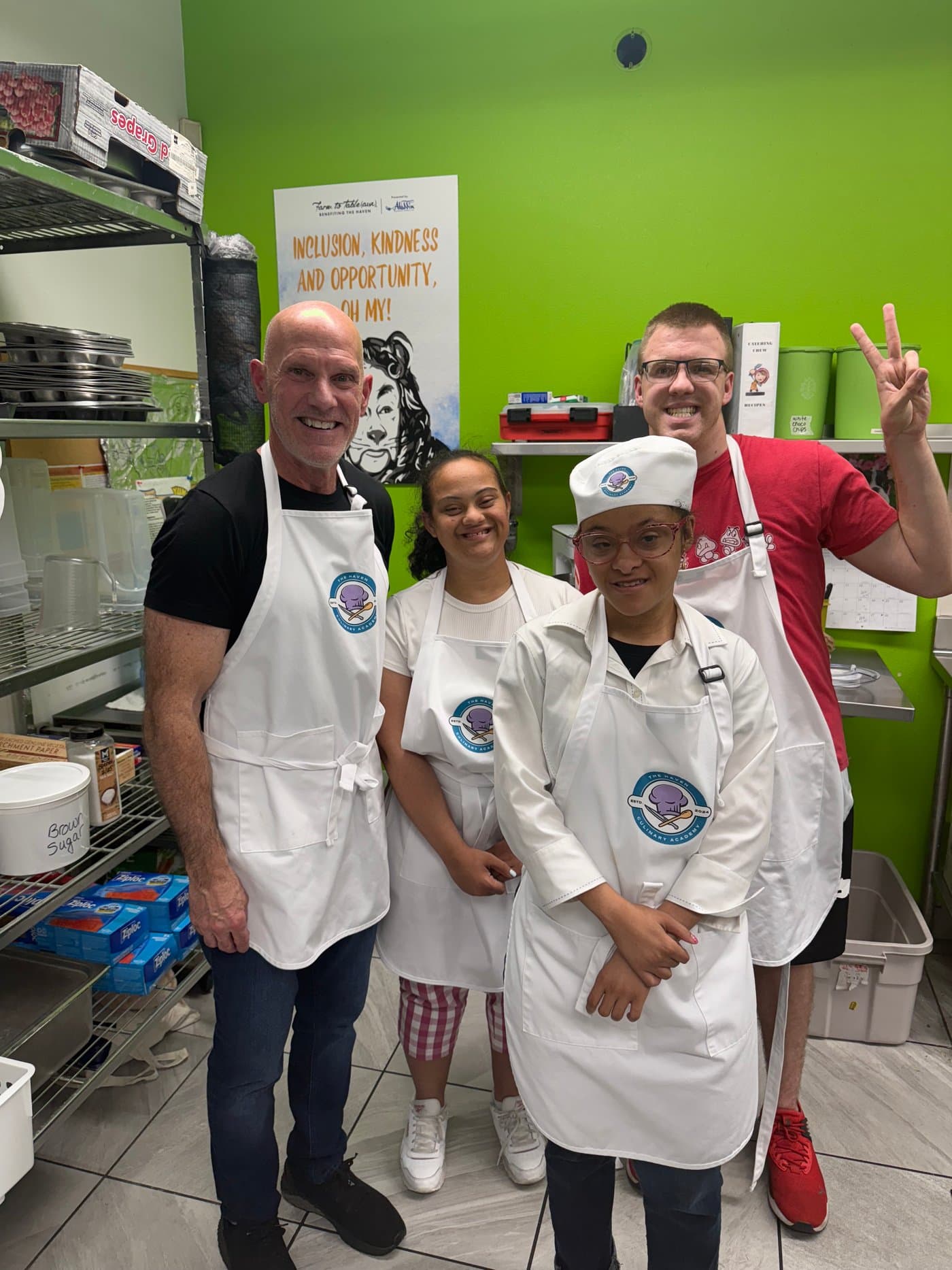 Four colleagues in aprons gathered in a kitchen